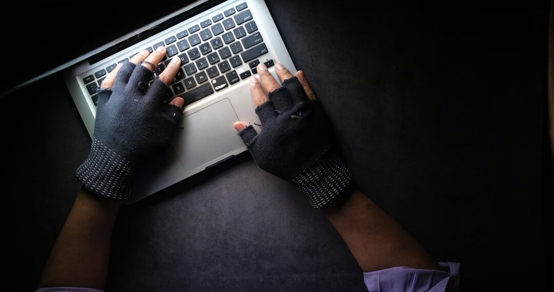 hacker hand stealing data from laptop top down