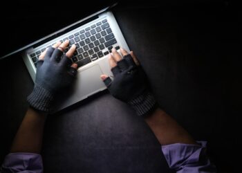 hacker hand stealing data from laptop top down