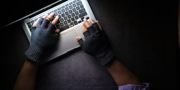 hacker hand stealing data from laptop top down