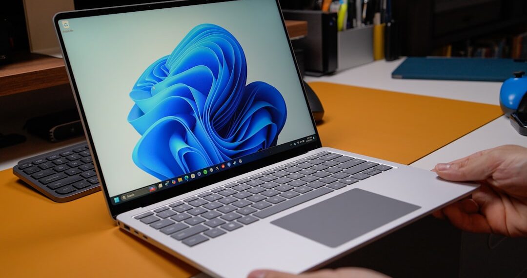 Windows laptop open on modern desk with blue wallpaper