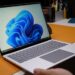 Windows laptop open on modern desk with blue wallpaper