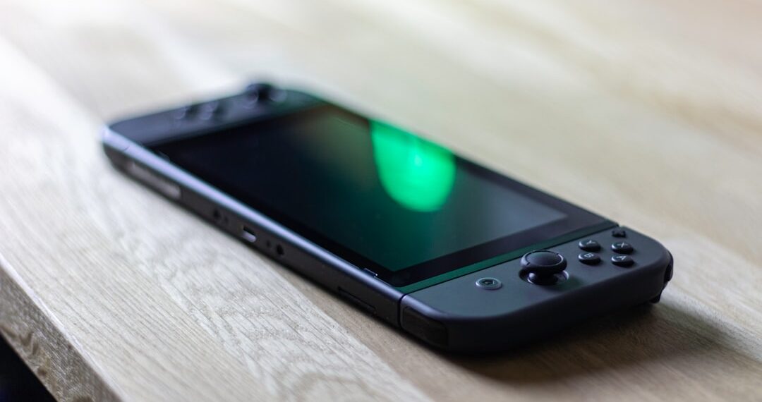 Nintendo Switch in black lying on my desk with a green reflection at the display