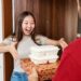 Excited Woman Receiving Food Delivery at Home Door from Courier