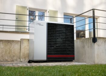 Eine moderne Luft/Wasser Wärmepumpe der Hybrox Serie vor einem Einfamilienhaus