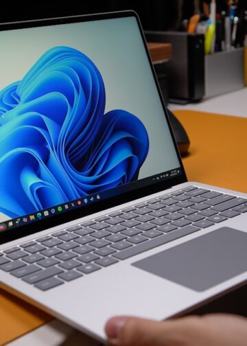 Windows laptop open on modern desk with blue wallpaper