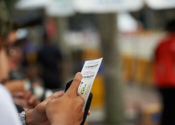 Man holding paper against blurred background