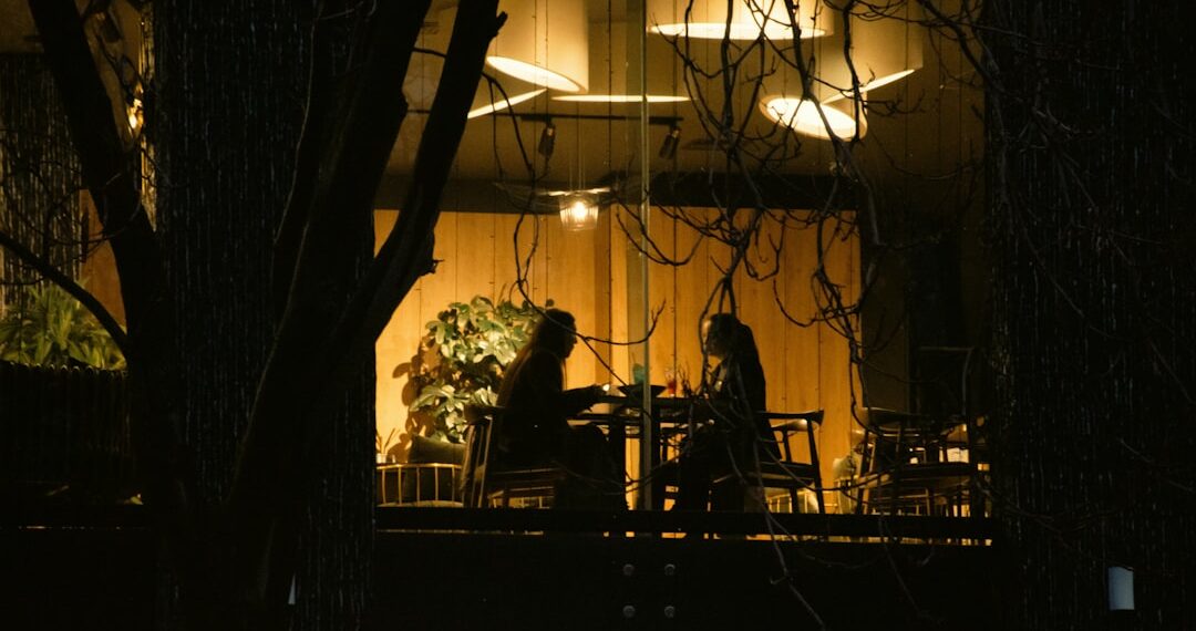 Twee mensen aan een tafel bij avondlicht