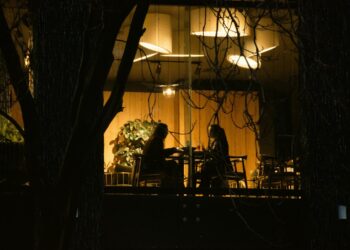 Twee mensen aan een tafel bij avondlicht
