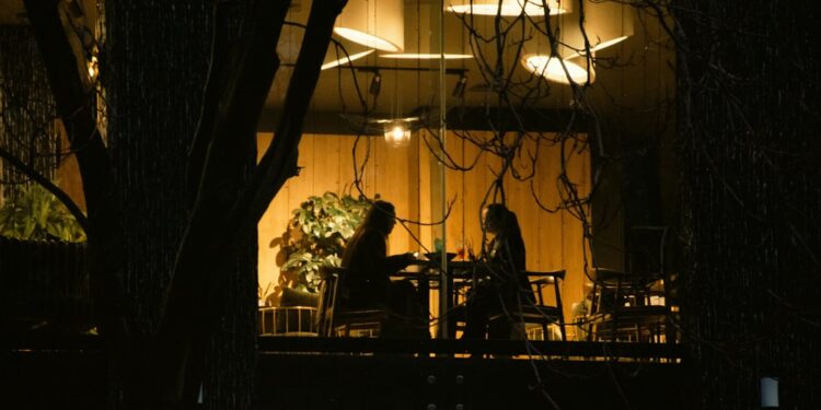 Twee mensen aan een tafel bij avondlicht