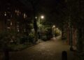 Free photo of street view in the evening in the old city of Amsterdam of an old lane named Laagte Kadijk, behind the old large Entrepotdok storage buildings to the left. Street photography free download for poster or wallpaper of old cities in The Netherlands by Fons Heijnsbroek, 2023. / Straat foto van de oude donkere groene straat Laagte Kadijk in Amsterdam bij avond; gratis download foto - straatfotografie Nederland van Fons Heijnsbroek in hoge resolutie foto.