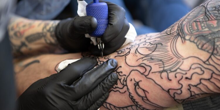 Tatoeëerder zet een tattoo