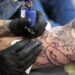 Tatoeëerder zet een tattoo