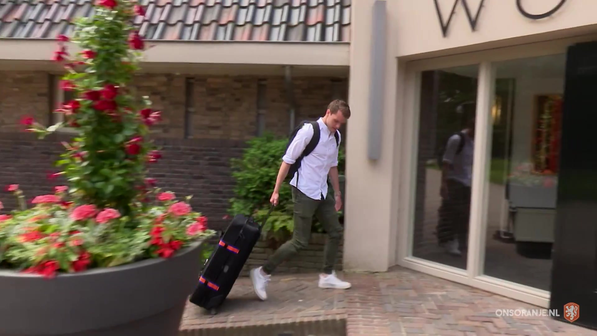 Speler van Oranje loopt met een koffer het hotel in Zeist binnen
