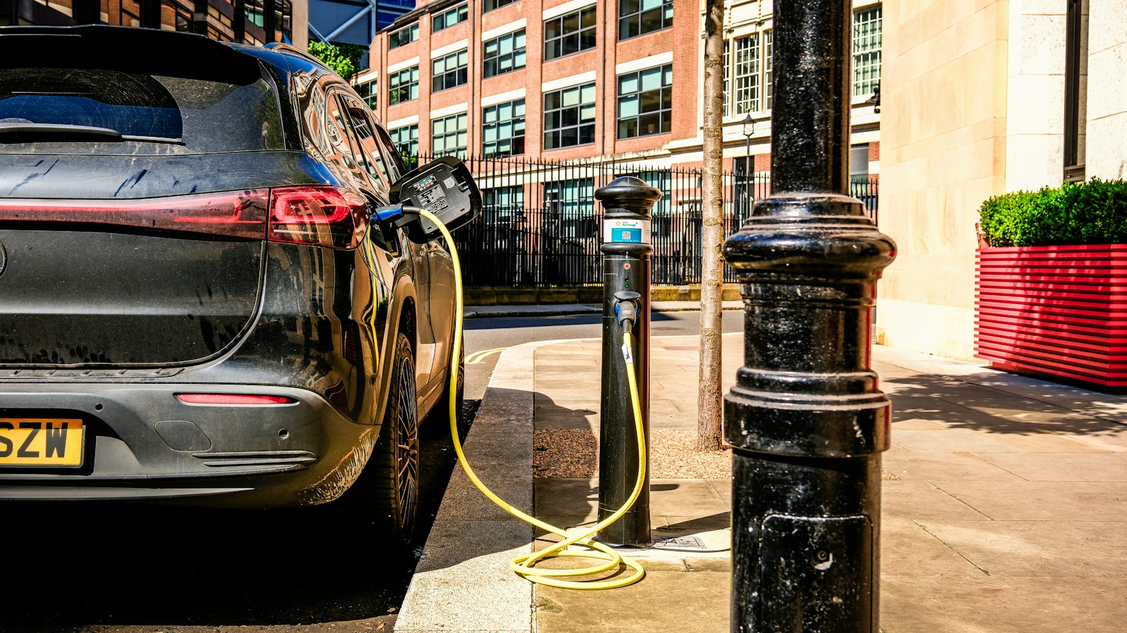 Tweedehands elektrische auto aan een laadpaal langs de straat