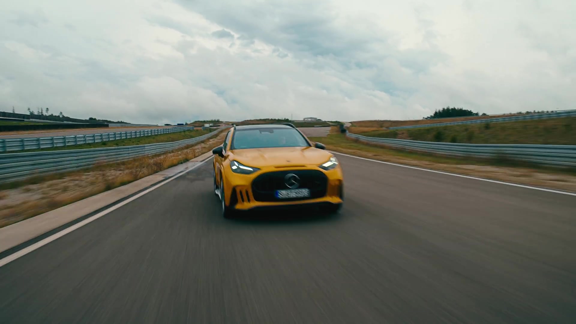 Gele Mercedes-AMG GT SUV rijdt op een circuit, van voren gezien
