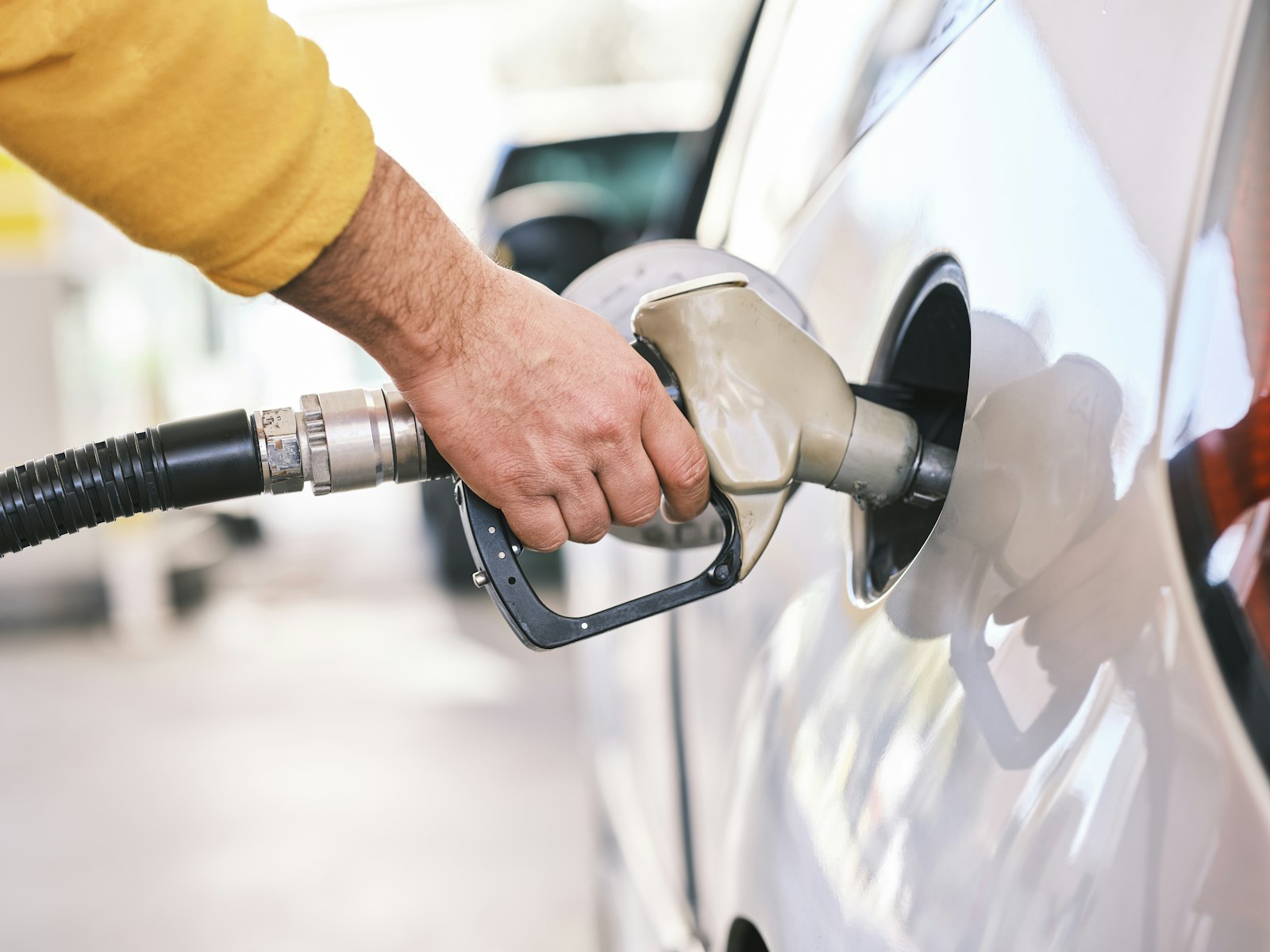 Tankpistool in de tank van een auto bij een tankstation