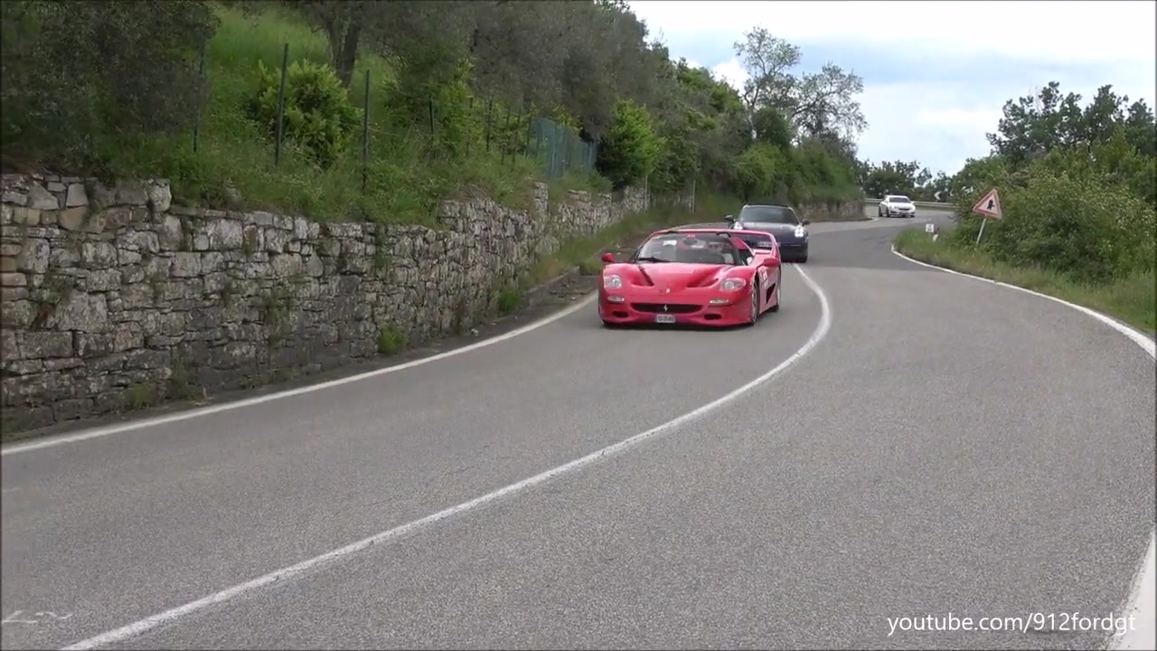 Rode Ferrari F50 rijdt door een bocht op een Italiaanse heuvelweg