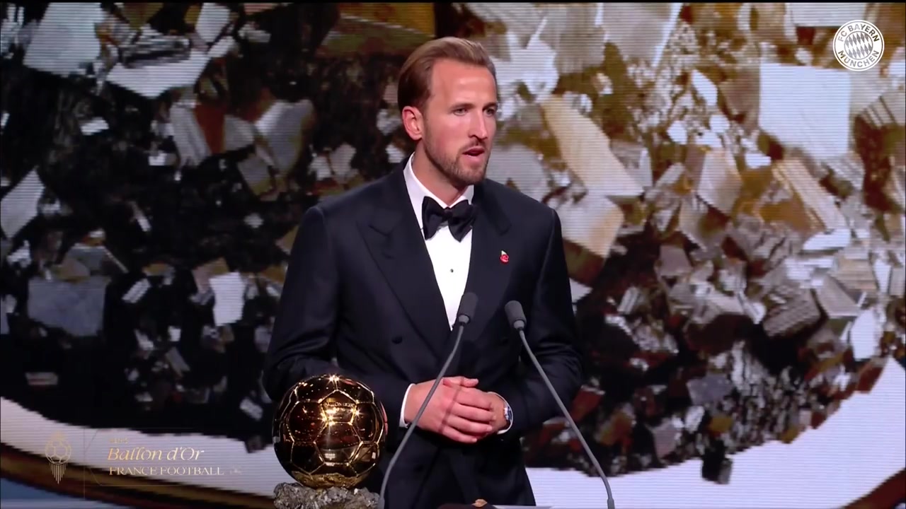 Harry Kane in smoking geeft zijn speech naast de Ballon d'Or