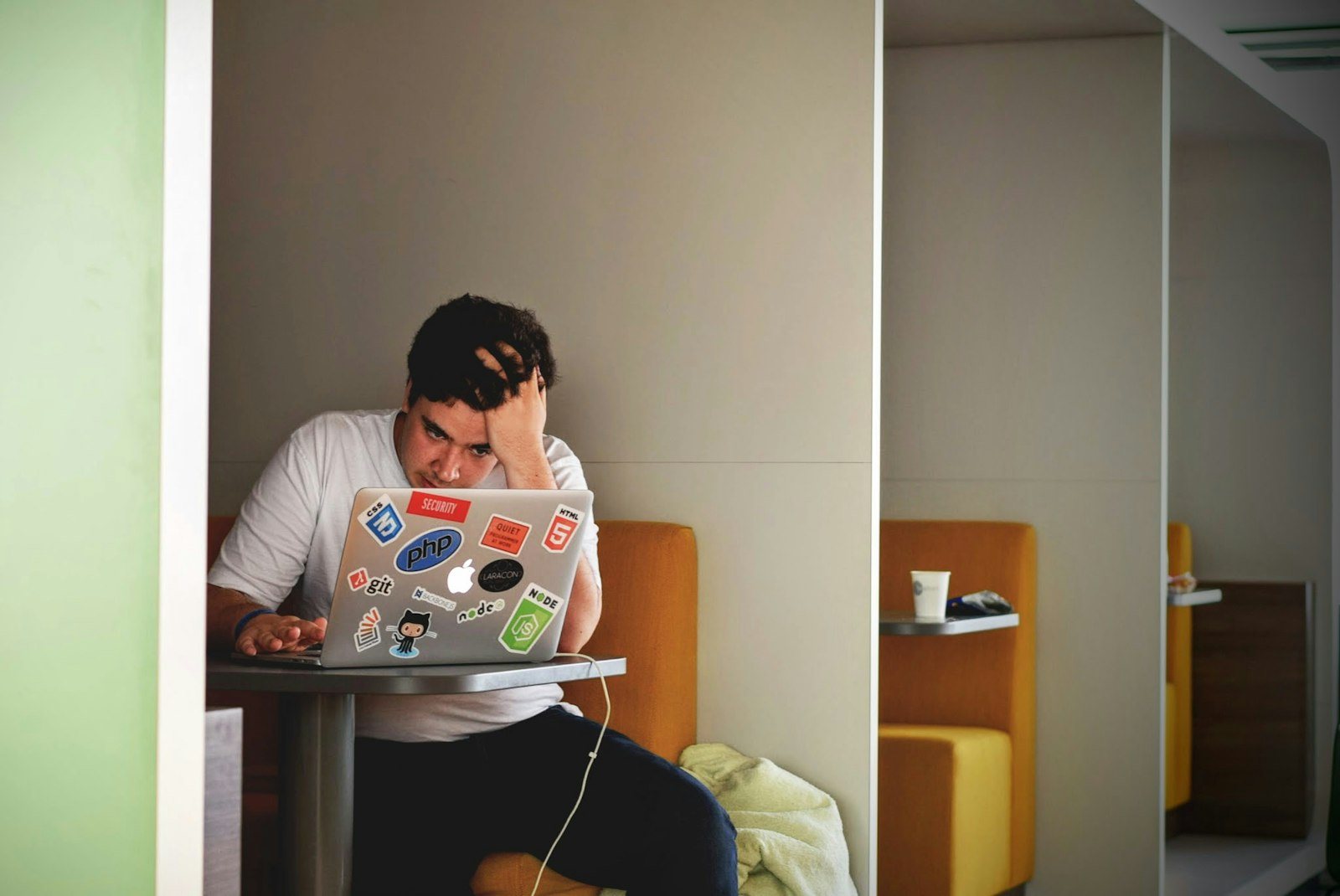 Student wrijft in zijn ogen achter een laptop