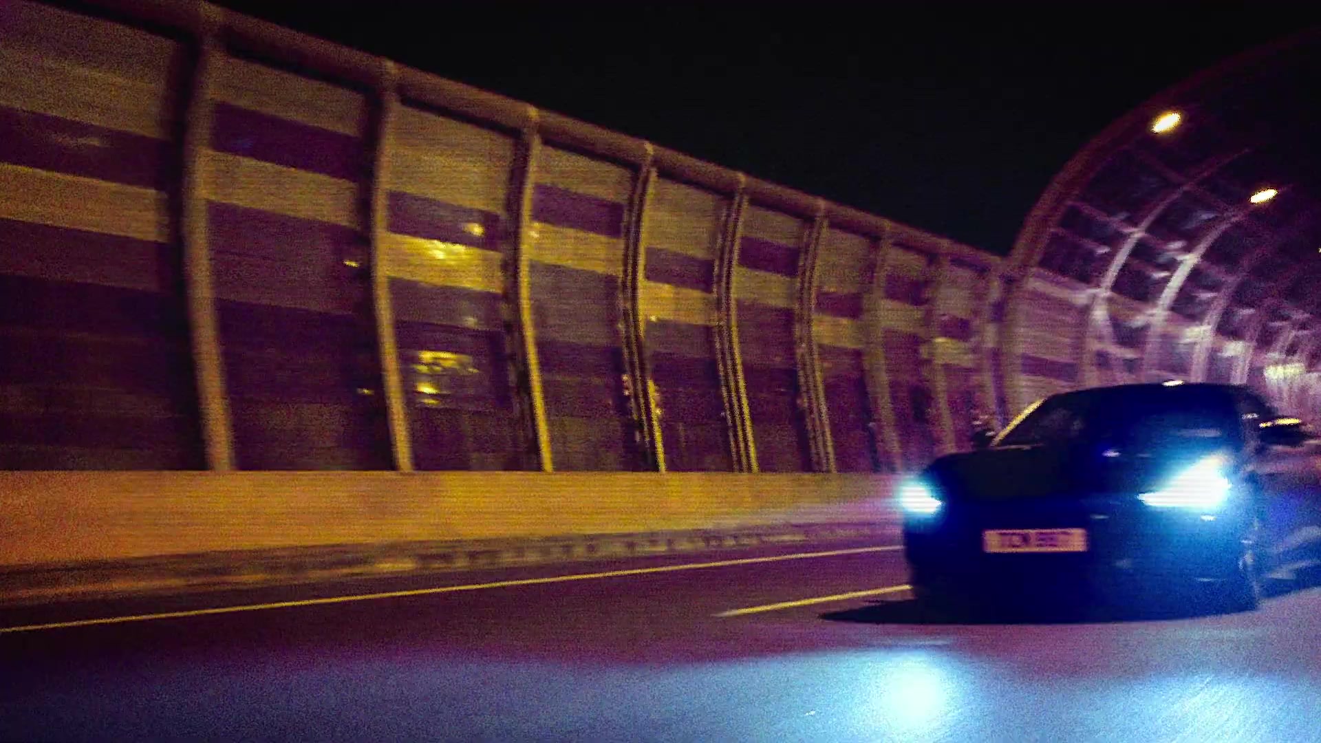 Jaguar Type 01 rijdt met brandende koplampen door een verlichte tunnel