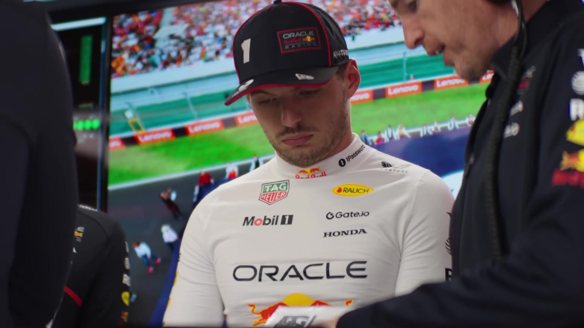 Max Verstappen in de garage van Red Bull Racing in overleg met een engineer