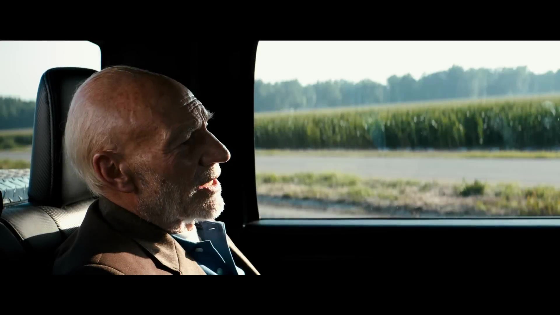 Patrick Stewart als Charles Xavier op de achterbank van een auto in de film Logan