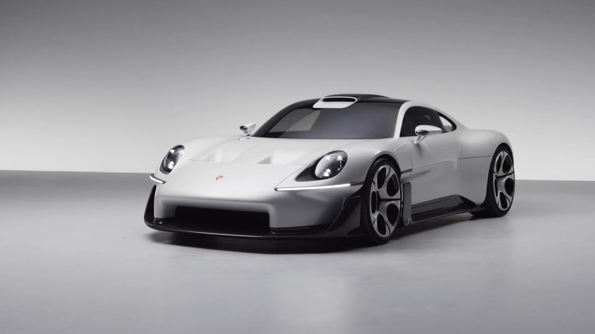 Witte Porsche Mission S schuin van voren in een lichte studio