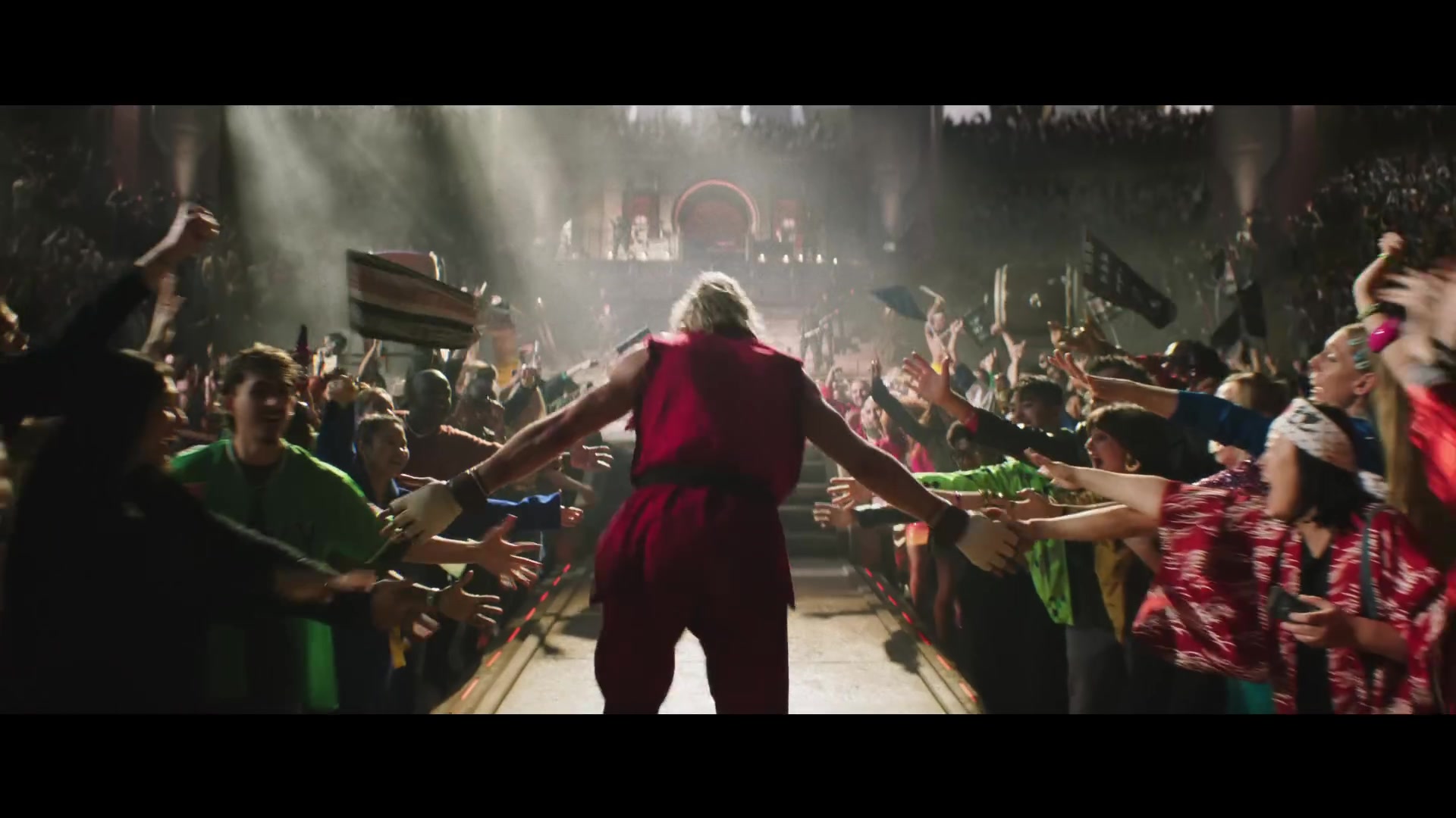 Ken Masters loopt in zijn rode pak een arena vol juichend publiek binnen in de film Street Fighter