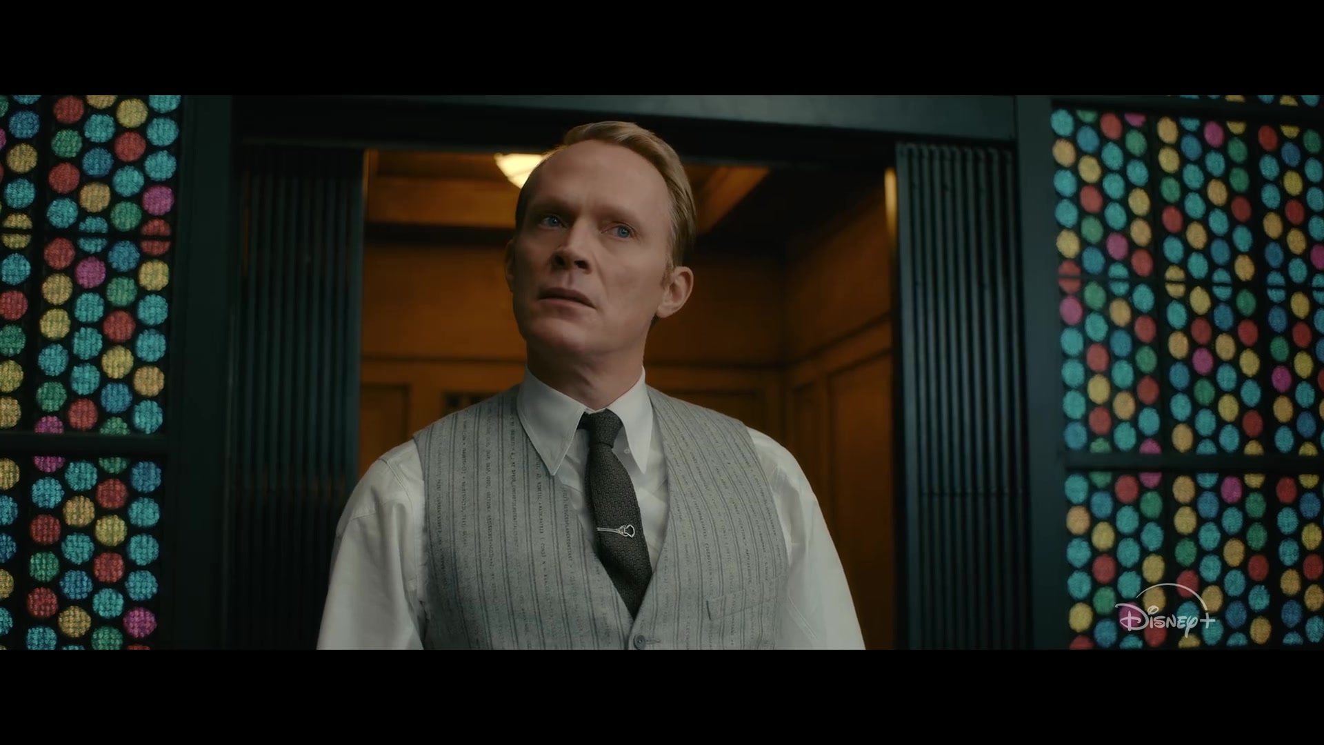 Paul Bettany als Vision in vest en stropdas tussen kleurrijk glas-in-lood, still uit de trailer van VisionQuest