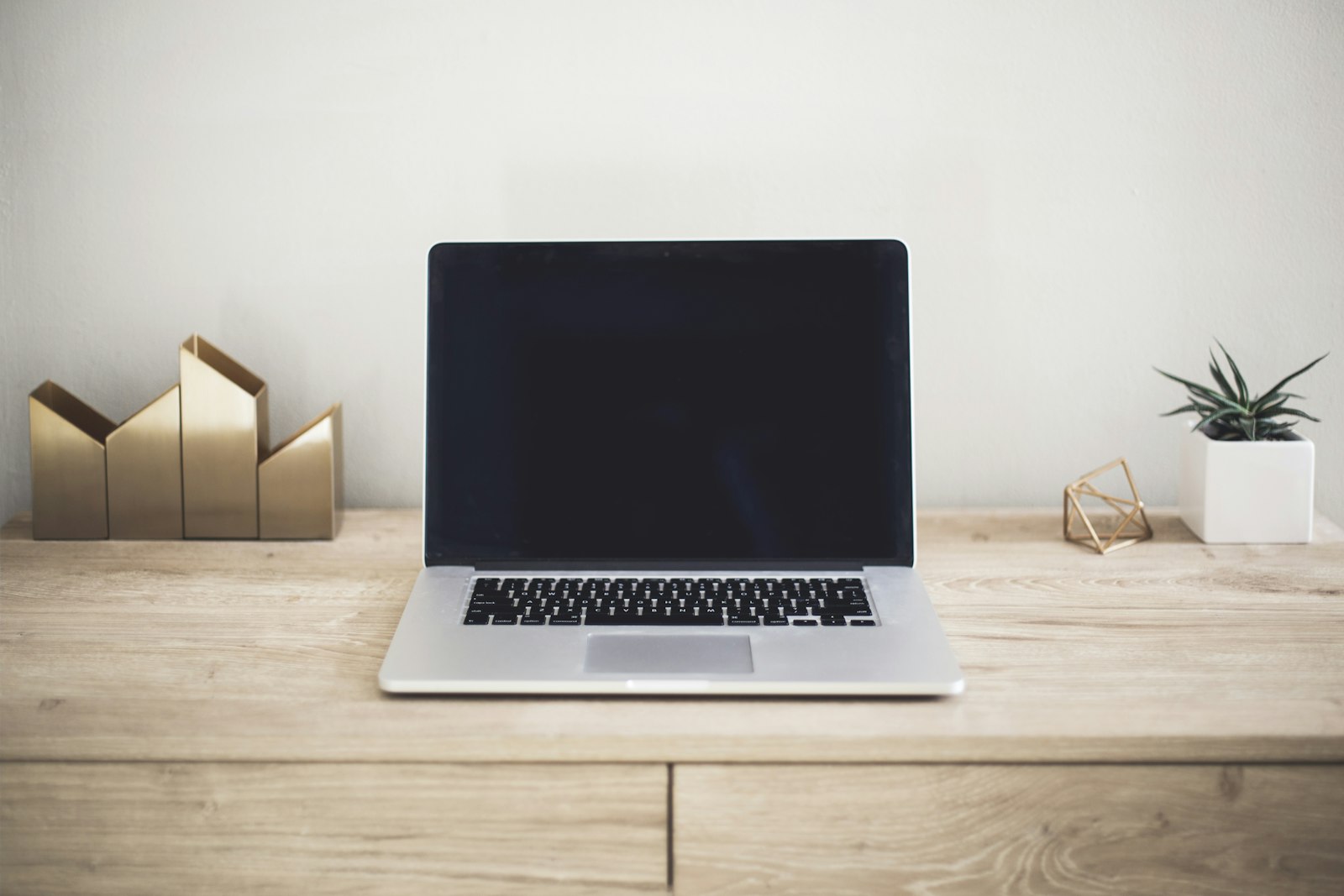 Laptop open op een bureau met een man die typt